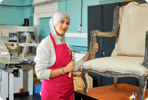 Student working on upholstering a chair