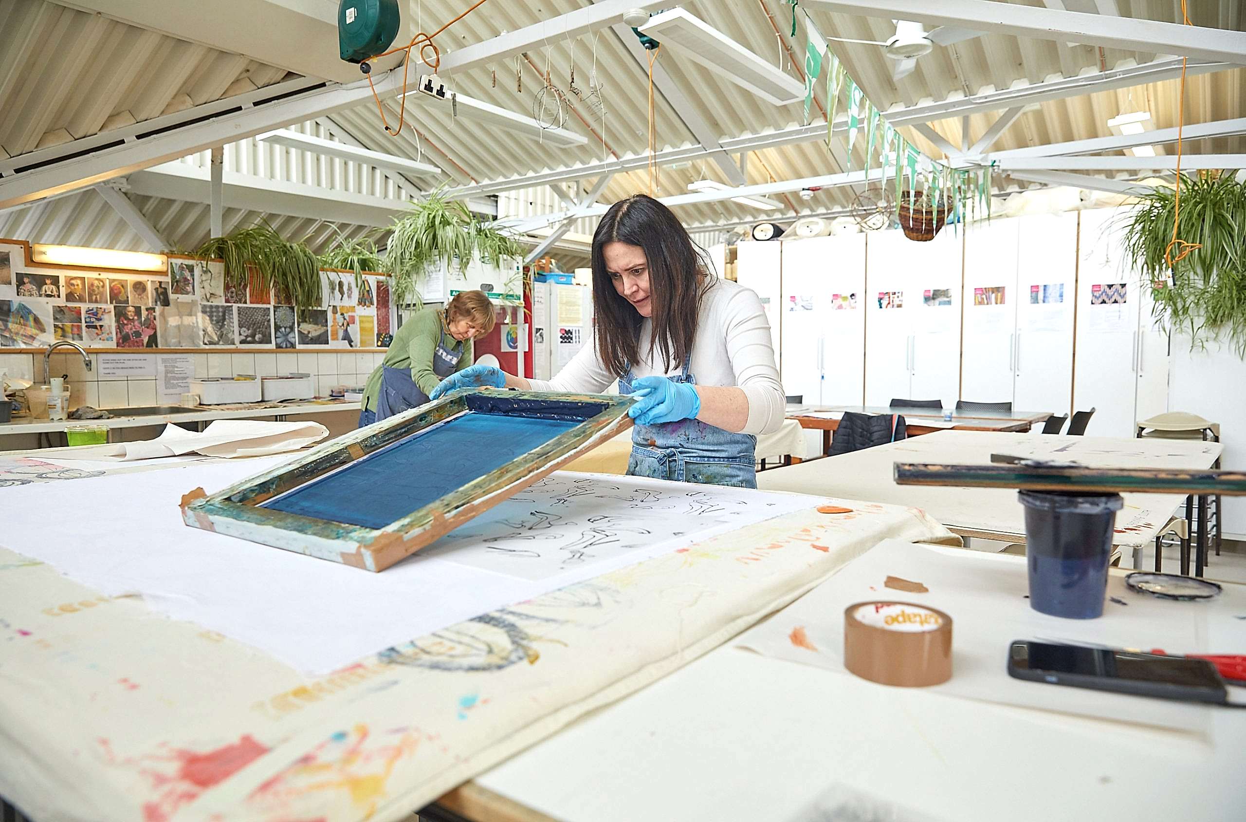 Dark haired women in textiles studio working on colour textiles